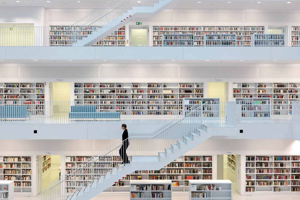 Inside of Stuttgart's municipal Library. A woman walks down the staircase.