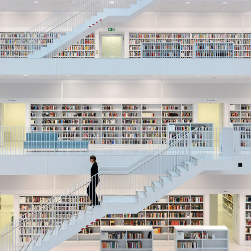 Inside of Stuttgart's municipal Library. A woman walks down the staircase.